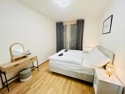 a bedroom with a bed and a desk and a mirror at New Luxury Apartmen at Andel Metro Station in Prague