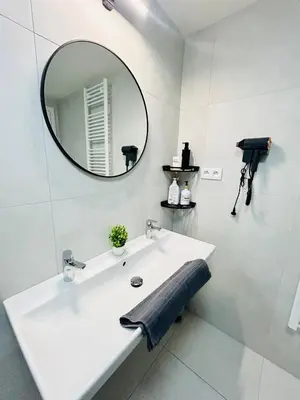 a white bathroom with a sink and a mirror at New Luxury Apartmen at Andel Metro Station in Prague