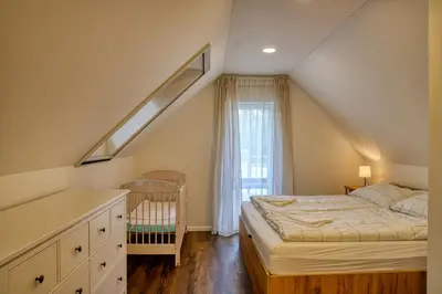 a attic bedroom with a bed and a window at House Big Win Mělník in Mlazice