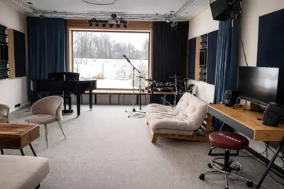a living room with a piano and a television at House Big Win Mělník in Mlazice