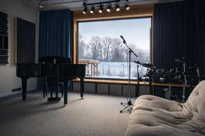 a living room with a piano and a room with a window at House Big Win Mělník in Mlazice