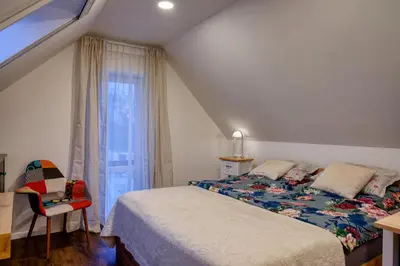 a bedroom with a bed and a chair and a window at House Big Win Mělník in Mlazice