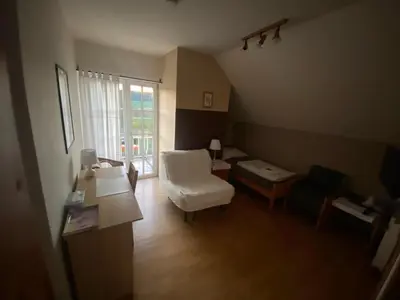 a living room with a white chair and a table at Penzion Červený mlýn in Rakovník