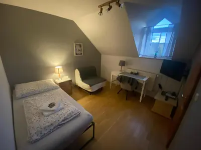 a room with two beds and a desk and a window at Penzion Červený mlýn in Rakovník