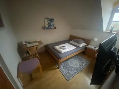 a small room with a bed and a table at Penzion Červený mlýn in Rakovník