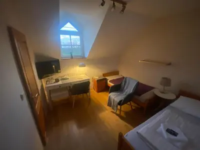 a small room with a bed and a desk and a chair at Penzion Červený mlýn in Rakovník