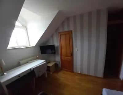 a room with a staircase with a television and a window at Penzion Červený mlýn in Rakovník