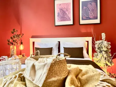 a bedroom with red walls and a bed with a blanket at Ruby Prague Apartment in Prague