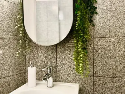a bathroom with a sink and a mirror on a wall at Ruby Prague Apartment in Prague