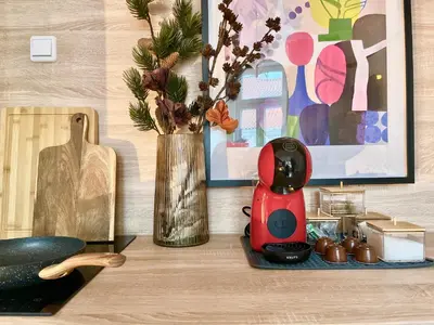 a table with a vase of flowers and a red blender at Ruby Prague Apartment in Prague