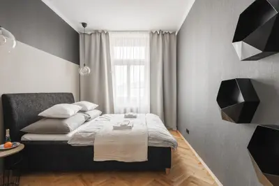 a small bedroom with a bed and a window at Francouzská Suites in Prague