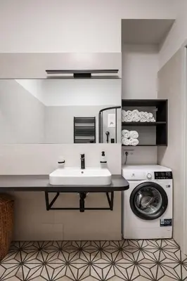 a bathroom with a sink and a washing machine at Francouzská Suites in Prague