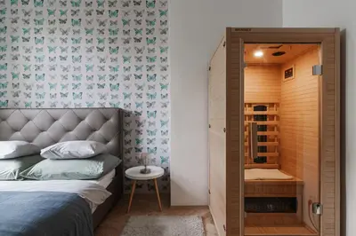 a bedroom with a bed and a small bathroom at Francouzská Suites in Prague