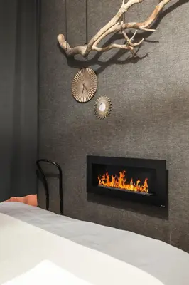 a living room with a fireplace with a bed at Francouzská Suites in Prague