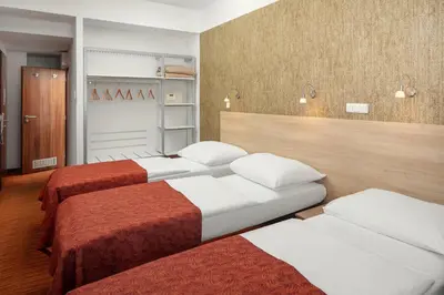 a room with three beds in a room at Hotel Ambiance in Prague