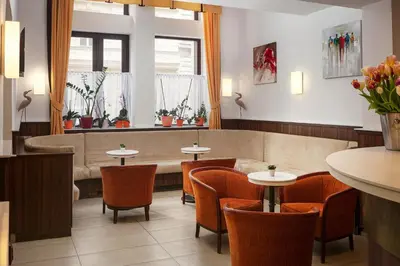 a waiting room with a couch and tables and chairs at Hotel Ambiance in Prague