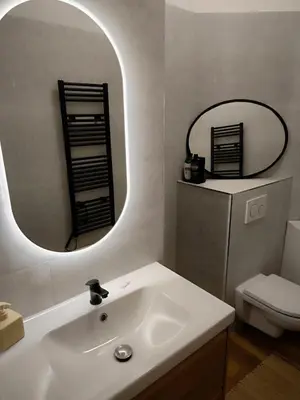 a bathroom with a white sink and a mirror at Arty Street Apartment Krymska in Prague