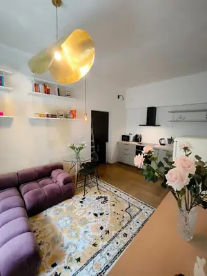 a living room with a purple couch and a table at Arty Street Apartment Krymska in Prague