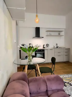 a living room with a purple couch and a table at Arty Street Apartment Krymska in Prague