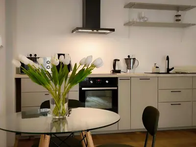 a kitchen with a table with a vase of flowers at Arty Street Apartment Krymska in Prague