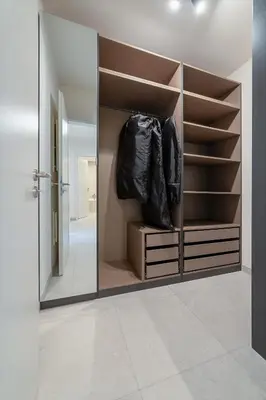 a mirror in a walk in closet with shelves at Chic Prague Living at Vista Serenity Apartment with Balcony in Prague