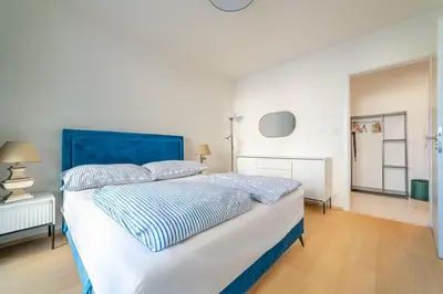 a large bed with a blue headboard in a bedroom at Chic Prague Living at Vista Serenity Apartment with Balcony in Prague