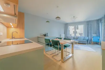 a kitchen and living room with a table and chairs at Chic Prague Living at Vista Serenity Apartment with Balcony in Prague