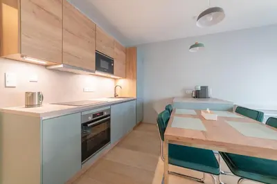 a kitchen with a table and chairs in a room at Chic Prague Living at Vista Serenity Apartment with Balcony in Prague