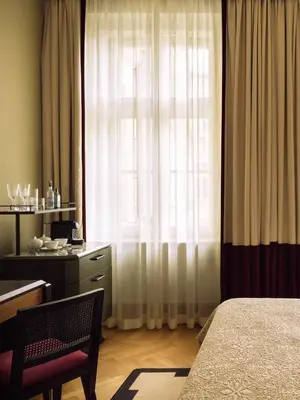 a bedroom with a bed and a desk and a window at Sir Prague, part of Sircle Collection in Prague