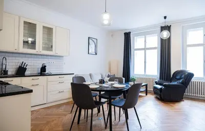 a kitchen and dining room with a table and chairs at Rentero Spacious Apartment near Prague Castle in Prague