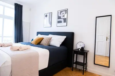 a bedroom with two beds and a mirror at Rentero Spacious Apartment near Prague Castle in Prague