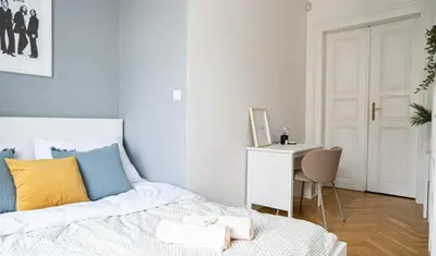 a bedroom with a bed and a desk with a chair at Rentero Spacious Apartment near Prague Castle in Prague