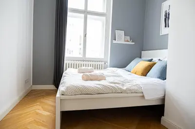 a white bed in a room with a window at Rentero Spacious Apartment near Prague Castle in Prague