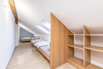 a room with a row of beds and shelves at Skyview Haven in Prague