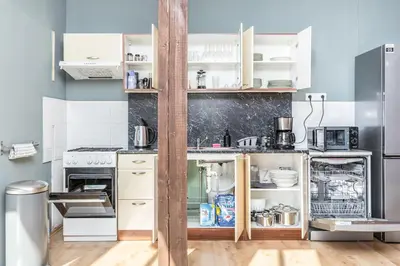 a small kitchen with white cabinets and appliances at Skyview Haven in Prague