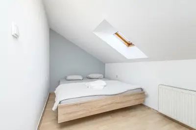 a bedroom with a bed in a white room at Skyview Haven in Prague