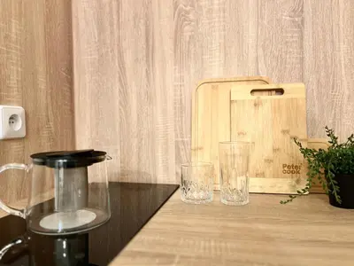 two glasses sitting on a wooden table with a juicer at Agate Prague Apartment in Prague