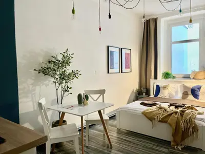 a white bedroom with a bed and a table at Agate Prague Apartment in Prague