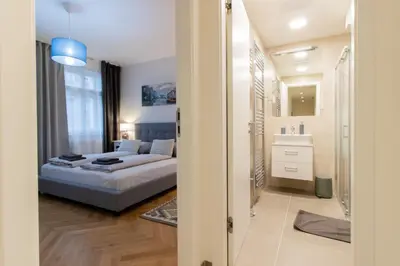 a bedroom with a large bed with blue curtains at Stay Inn Apartments Seifertova in Prague