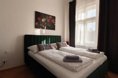 a bed in a room with a window at Stay Inn Apartments Seifertova in Prague