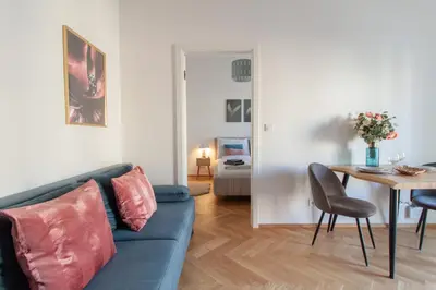 a living room with a blue couch and a table at Stay Inn Apartments Seifertova in Prague