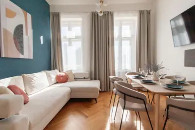 a bedroom with a large white bed with a blue wall at Stay Inn Apartments Seifertova in Prague