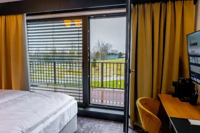 a bedroom with a bed and a window with a view at Hotel NOBILIS - Mladá Boleslav in Bradlec