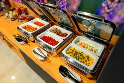 a buffet with several trays of food on a table at Hotel NOBILIS - Mladá Boleslav in Bradlec