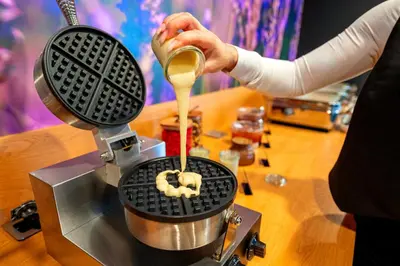 a person is pouring peanut butter into a food processor at Hotel NOBILIS - Mladá Boleslav in Bradlec