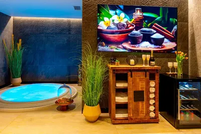 a bathroom with a tub and a tv on a wall at Hotel NOBILIS - Mladá Boleslav in Bradlec