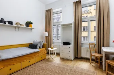 a bedroom with a bed and a desk and a window at Stay2gether - Vacation at grandma's in Prague