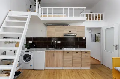 a small kitchen with a staircase leading up to a loft at Stay2gether - Vacation at grandma's in Prague
