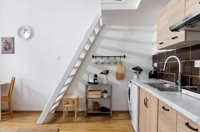 a kitchen with white walls and a white staircase at Stay2gether - Vacation at grandma's in Prague