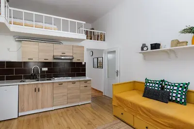 a kitchen with a yellow couch in a room at Stay2gether - Vacation at grandma's in Prague